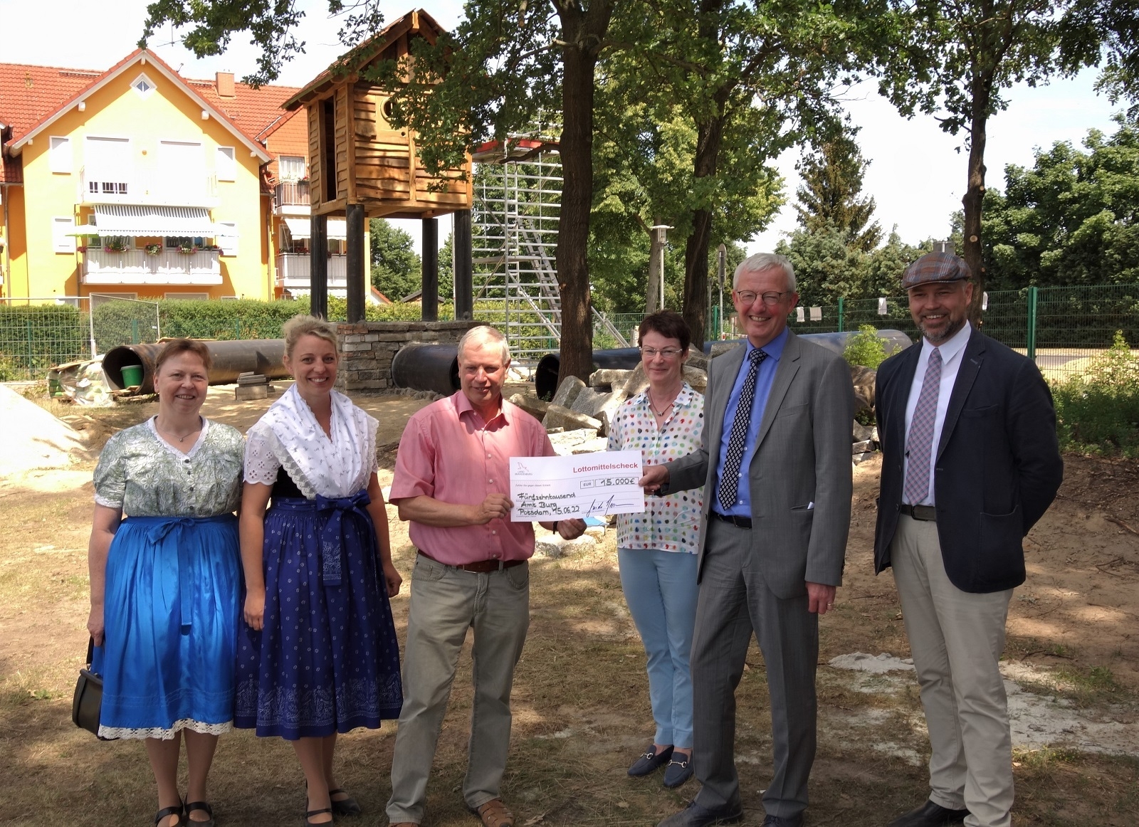 Bild: Vor der Baustelle des künftigen Abenteuerspielplatzes übergab Infrastrukturminister Guido Beermann (2. v. r.) den symbolischen Scheck an Bürgermeister Joachim Dieke und an die Vorsitzende des Traditionsvereins Werben, Madeline Koalick (2. v. l.). Auch Amtsdirektor Tobias Hentschel (r.), Landtagsabgeordnete Roswita Schier (hi.) und Sorben-/Wendenbeauftragte Anett Sischke (l.) freuen sich über die großartige Unterstützung. (Foto: K. Möbes)