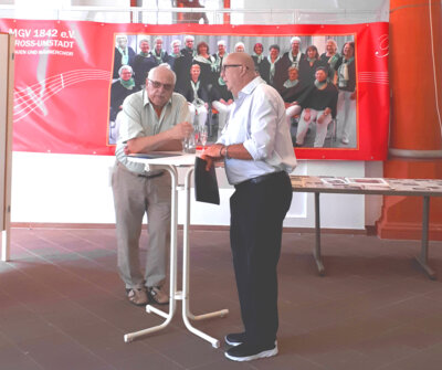 Gesch&auml;ftsf&uuml;hrer des S&auml;ngerkreises im Gespr&auml;ch mit dem 1. VorsitzendenAlwin Krehert, beobachtet vom Frauenchor des MGV  (Bild vergr&ouml;&szlig;ern)