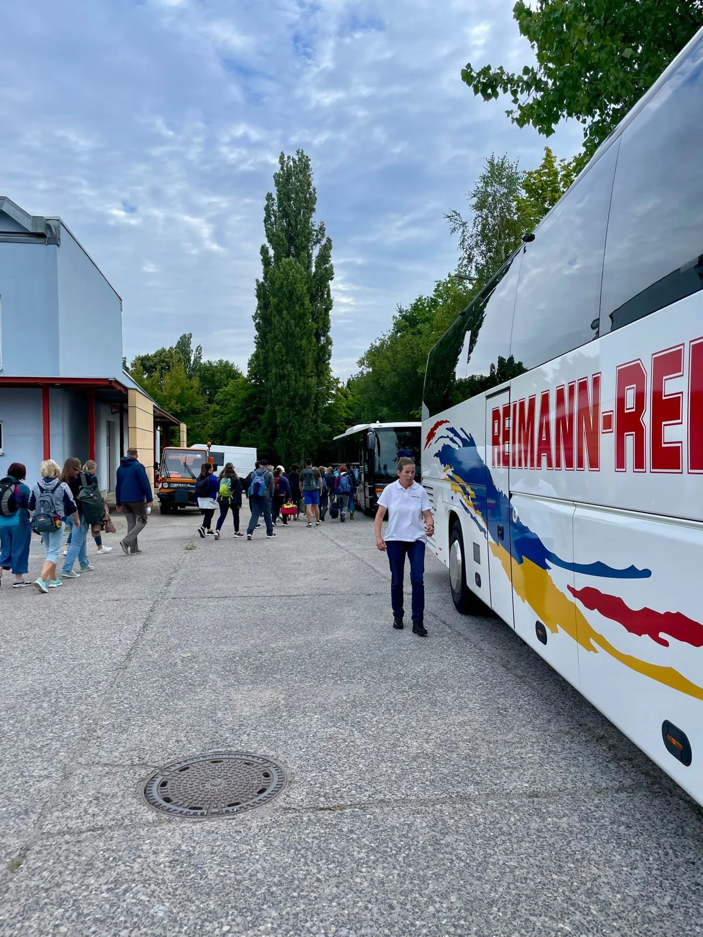 Bild: Reisebus, Parkplatz, Personen steigen in Busse