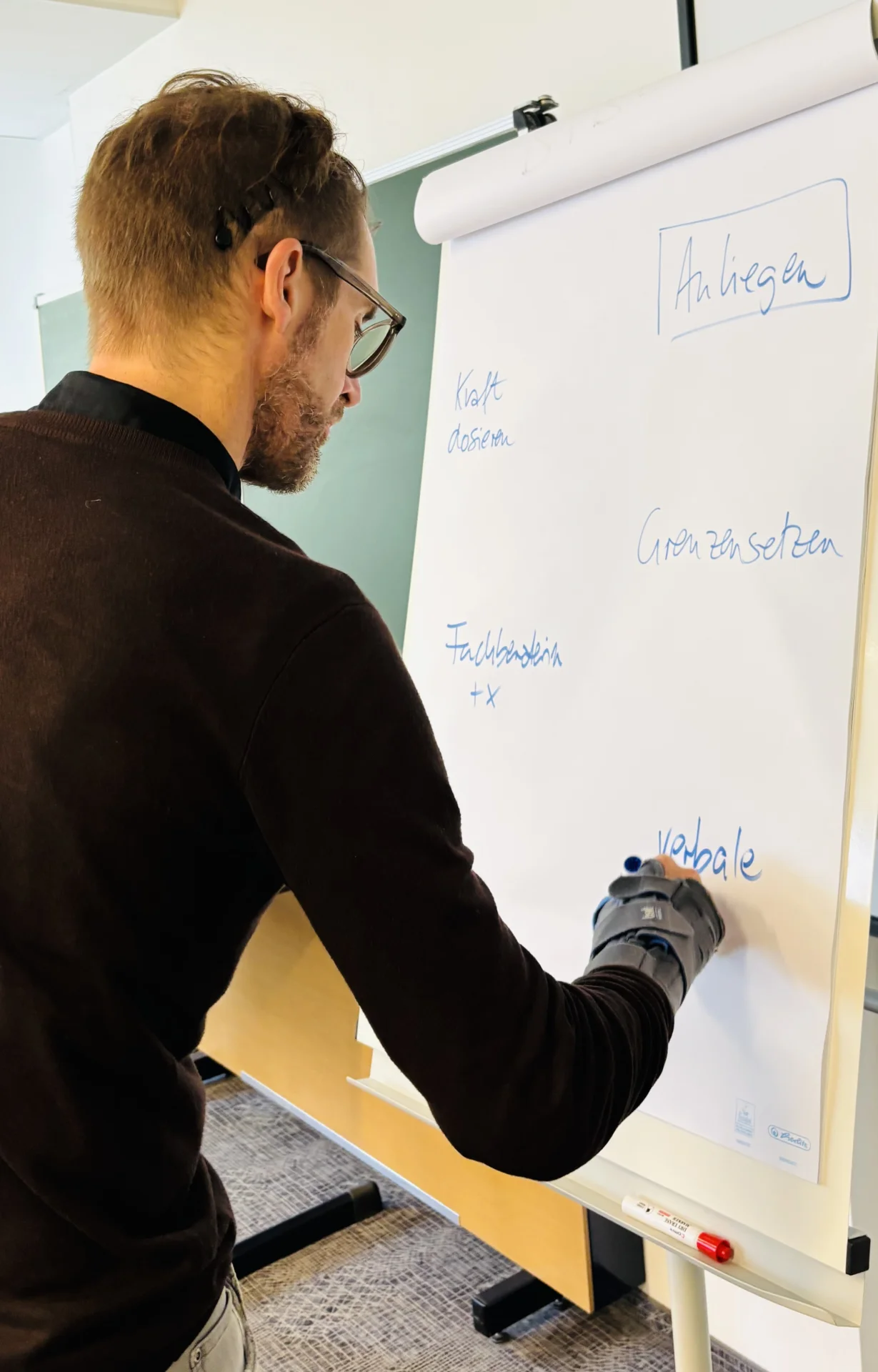 Bild: Dozent notiert Sachen an ein Flipchart