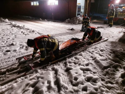 Angeleint geht ein Rettungstrupp mit Leitern auf dem Eis vor 