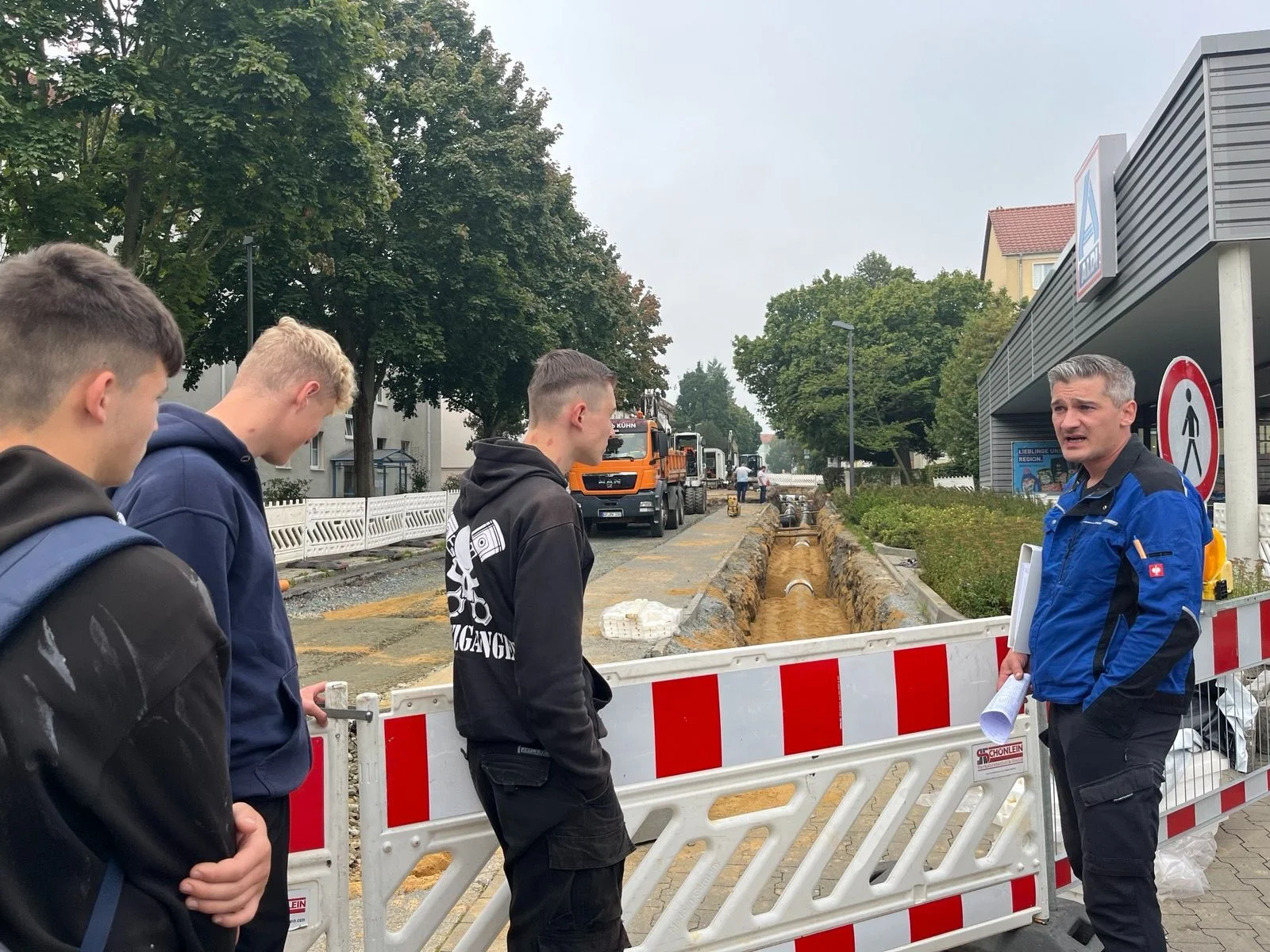Bild: Bauleiter erklärt einzelnen Schülern Straßenumbaumaßnahmen