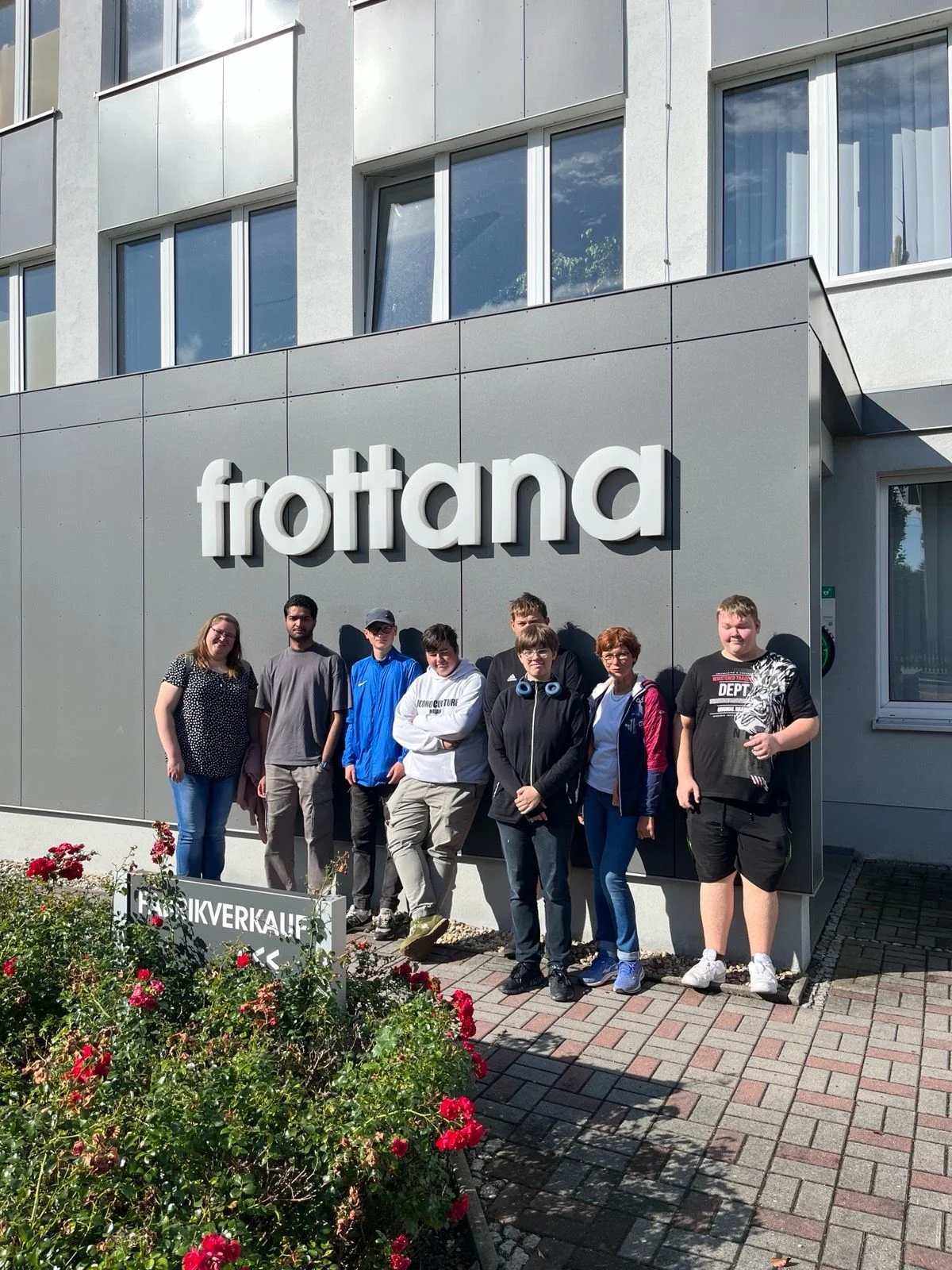 Bild: Schülergruppe steht vor einem Produktionsgebaude der Firma Frottana