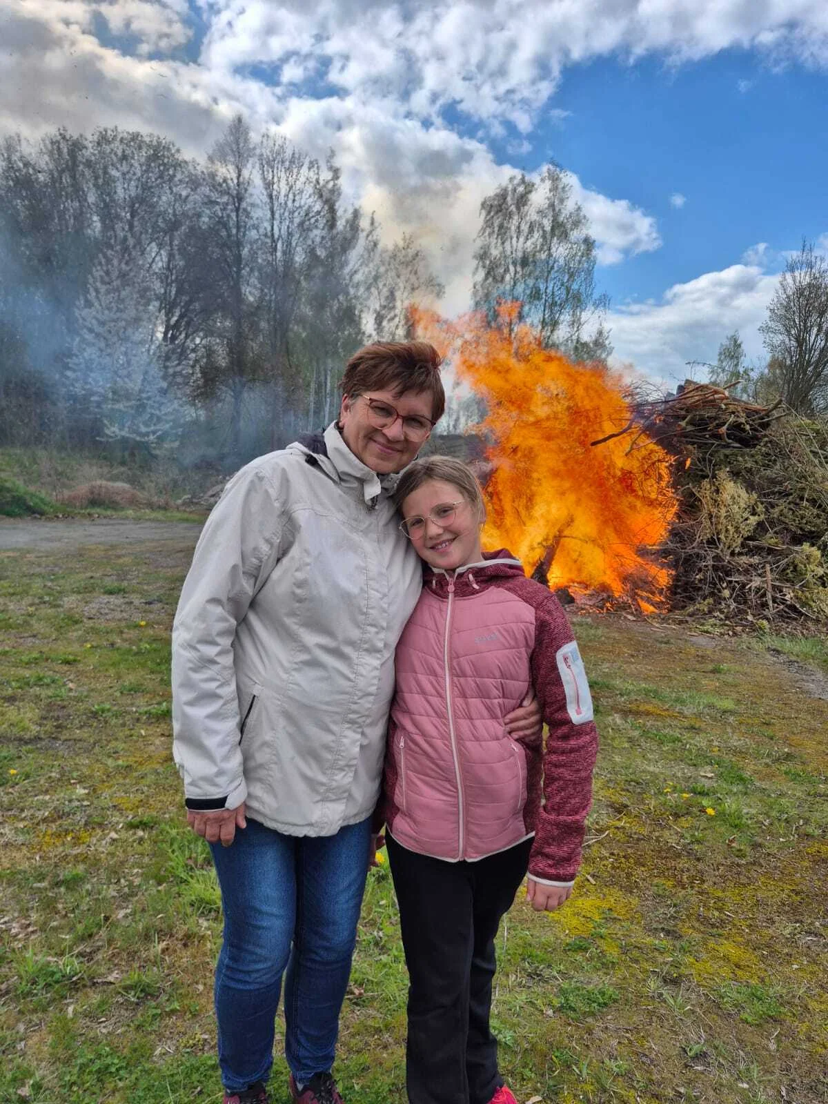 Bild: Schulleitung mit Kind vor Frühjahrsfeuer