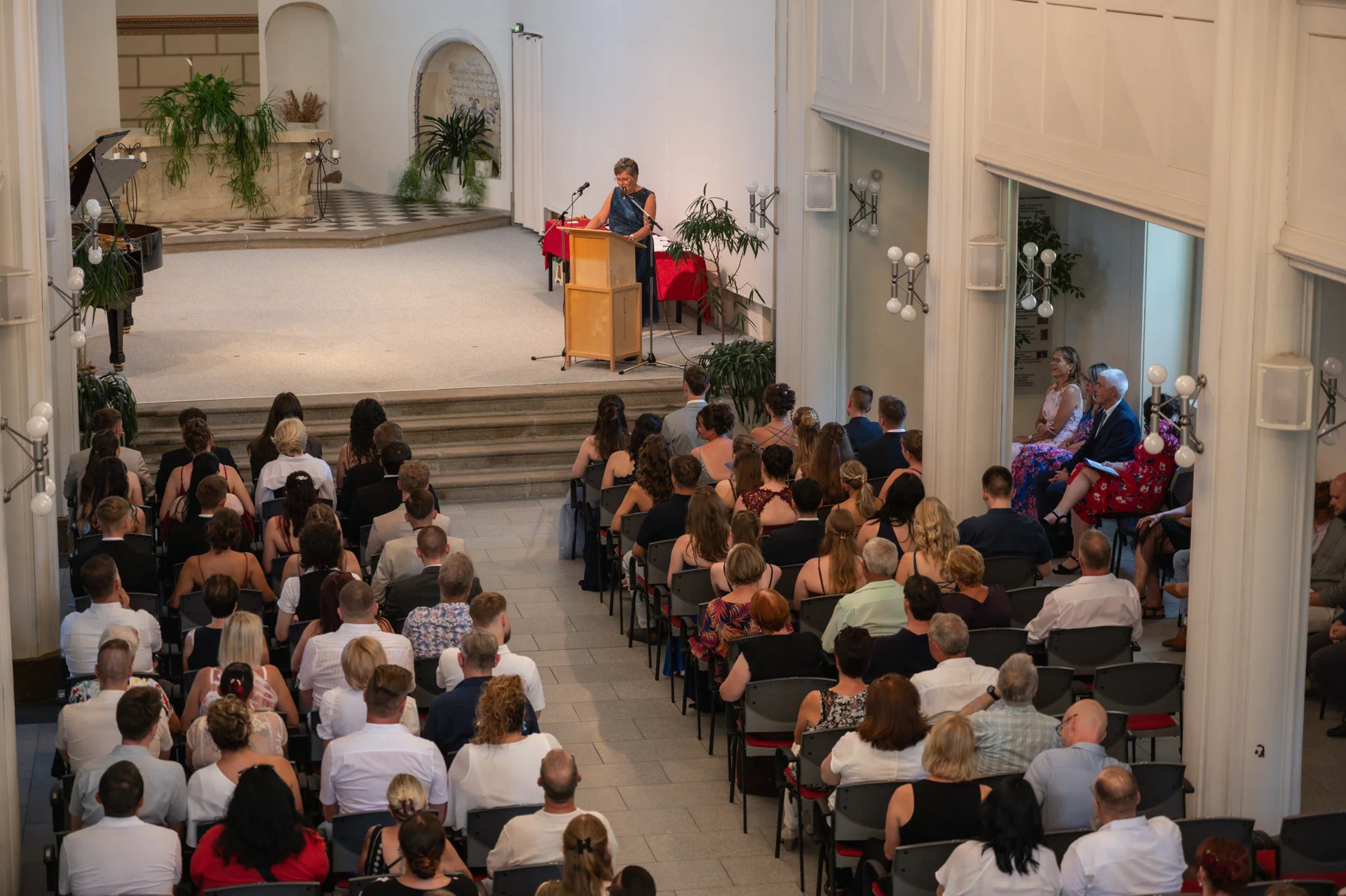 Bild: Absolventen und Familien sitzen in der Johanniskirche und hören Rede der Schulleiterin.