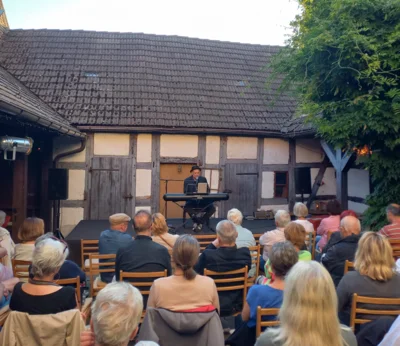 Foto des Albums: Der Berliner Liedermacher und Musikproduzent Andreas Albrecht gibt im Rahmen der Liedertour ein Hofkonzert im alten Pfarrhof