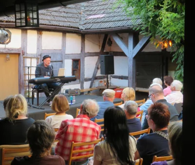 Foto des Albums: Der Berliner Liedermacher und Musikproduzent Andreas Albrecht gibt im Rahmen der Liedertour ein Hofkonzert im alten Pfarrhof