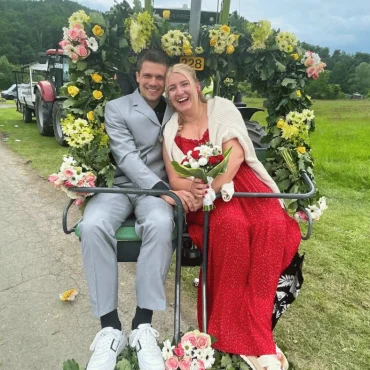 2 personen vor Blumenkranz