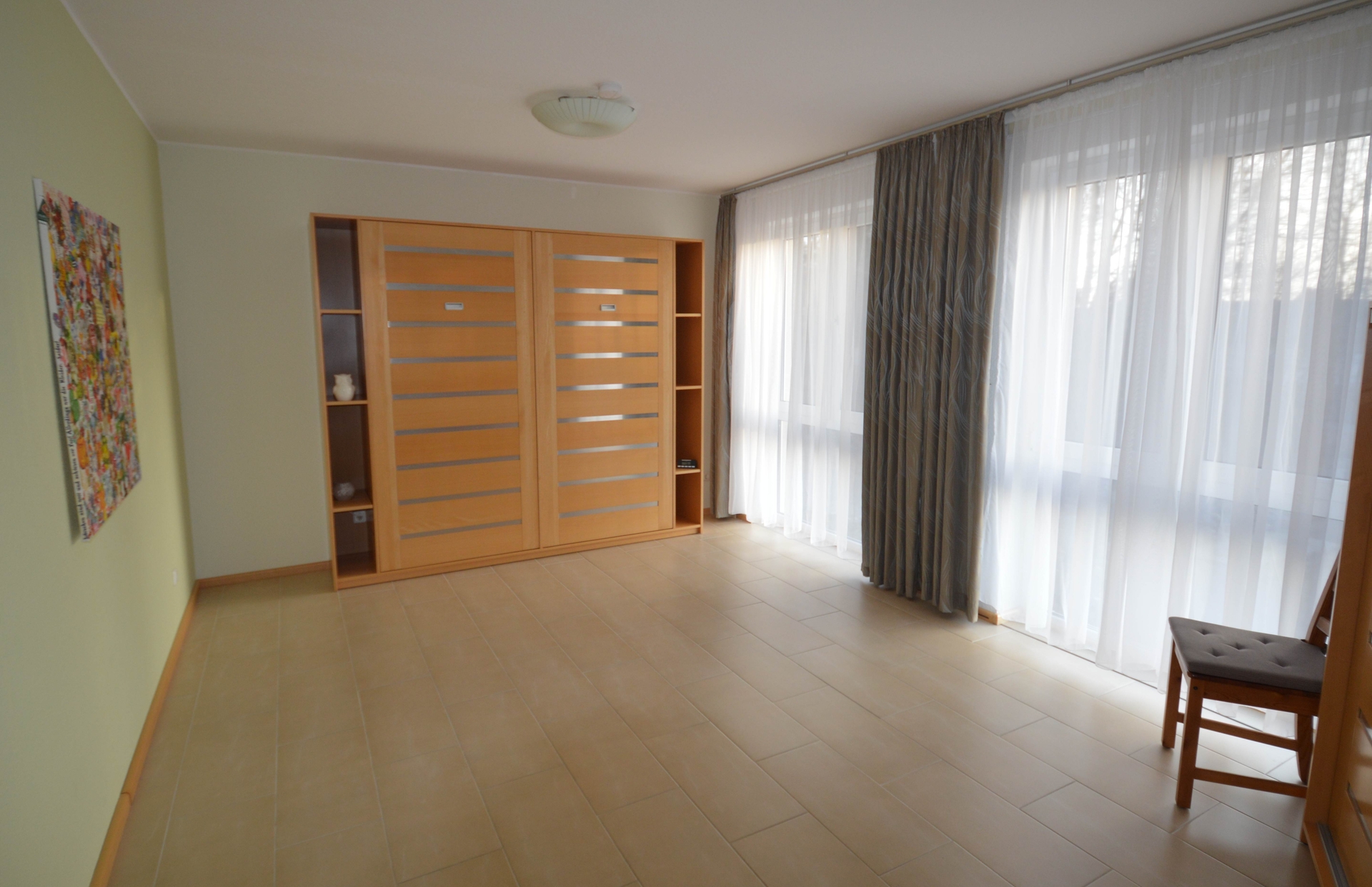 Bei schlechtem Wetter k&ouml;nnen die Schrankbetten auch hochgeklappt werden. Dann steht Kindern viel Platz zum Spielen zur Verf&uuml;gung. Gegen&uuml;ber den Betten steht ein Kleiderschrank.  (Bild vergr&ouml;&szlig;ern)