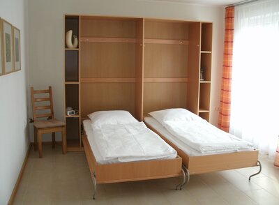 Vorschaubild: Here both cupboard beds are folded out in the bedroom or children's room. Opposite the beds is a wardrobe.