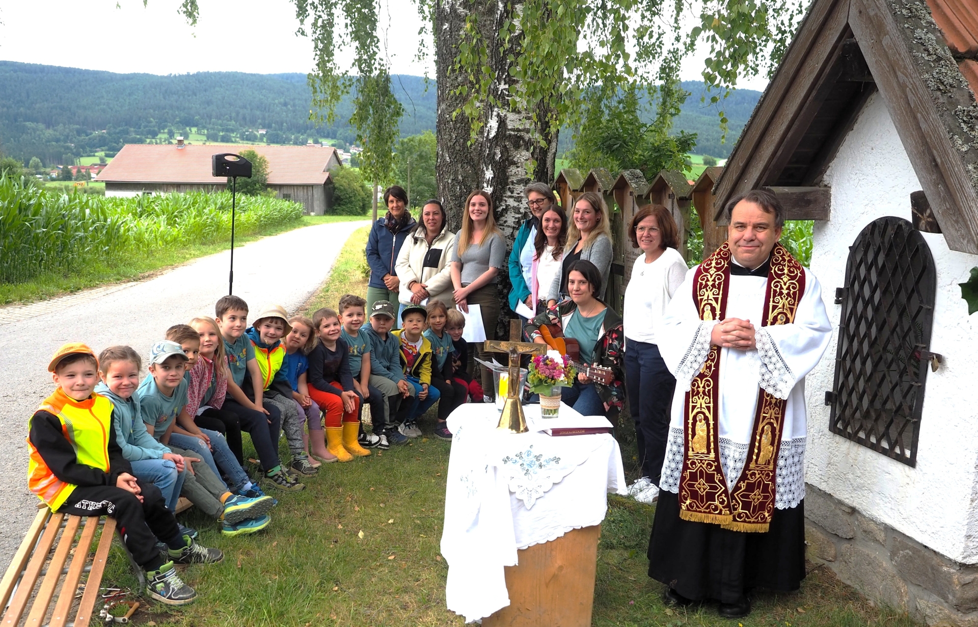 Bild: Bild: Eine schöne Abschlussandacht mit Pfarrer Josef Gallmeier am Lerchenholzmarterl neben dem Waldkindergarten vereinte die aus dem Kindergarten scheidenden Vorschulkinder und ihre Erzieherinnen. Foto: Hans Weiß