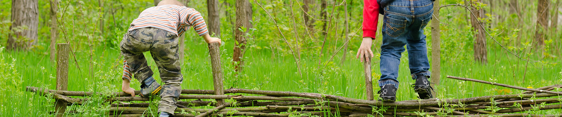 Kinder klettern über ein Zaun