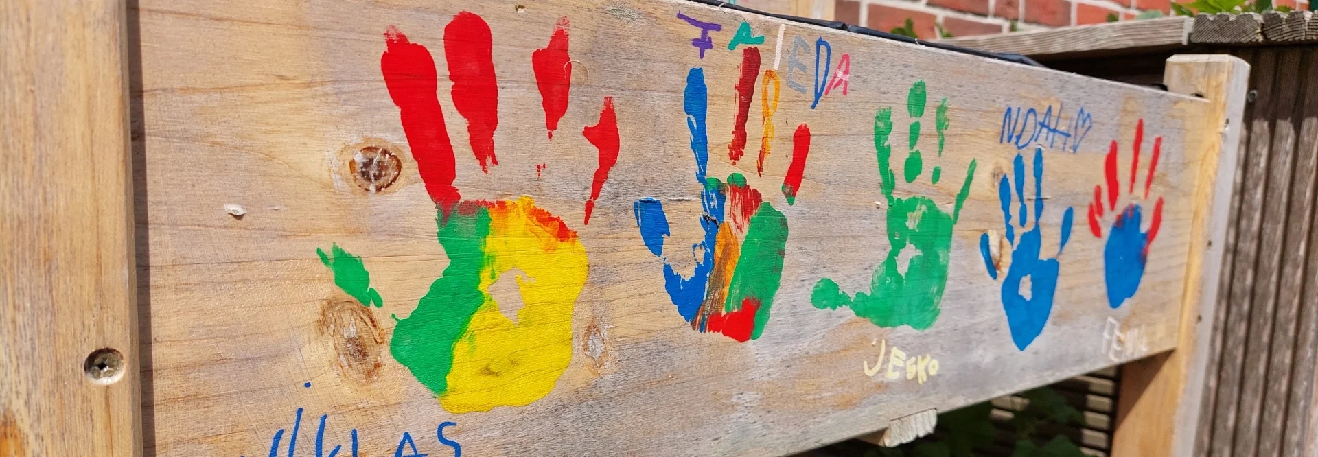 Ein Blumenkasten, mit bunten Handabdrücken von Kindern gestaltet