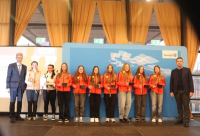 Bild (v.l.): Minister Helmut Holter, Sportlehrern Katrin Wenzel, Trainerin Alina Hunger, Jasmin Lehmann, Antonia Barth, Joann Lehmann, Melina Burkhardt, Angelina Barth, Dunja Pauler, Lara König, Referatsleiter Michael Rutz (Foto TMBJS)