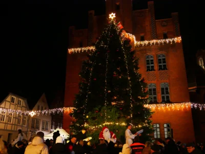 Foto: Rolandstadt Perleberg/Renè Hill | Unter dem beleuchteten Weihnachtsbaum verschenkten Bürgermeister Axel Schmidt, der Nikolaus und seine Engel Weihnachtskalender an die Kinder.