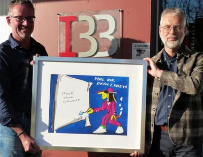 Reiner Buss (links) nimmt den „Stark ohne Gewalt“-Druck des Künstlers Udo Lindenberg aus den Händen von Norbert Wiemer, Vorstandsvorsitzender der Bürgerstiftung Westmünsterland, am Firmensitz in Ahaus entgegen. Foto: Bürgerstiftung WML