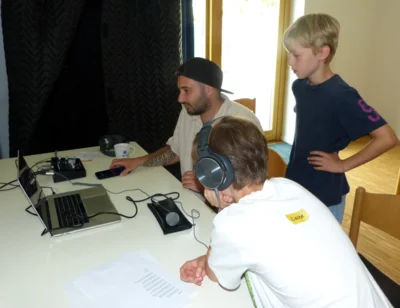 Dennis Buss nimmt mit den jungen Workshop-Teilnehmern den Freundschaftssong auf. Foto: Bürgerstiftung WML