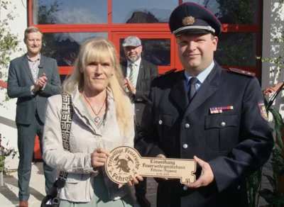 Bürgermeisterin Ira Frackmann übergibt den symbolischen Schlüssel für das neue Feuerwehrgerätehaus an Ortswehrführer Maik Eckert. Im Hintergrund Landrat Martin Heusler (l.) und Amtsdirektor Tobias Hentschel. (Foto. K. Möbes) (Bild vergr&ouml;&szlig;ern)