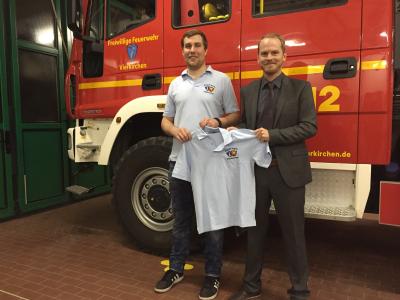 Geschäftsstellenleiter Alexander Schnell übergibt ein Poloshirt an Jugendwart Simon Danzer