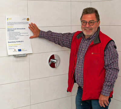 Dank der Förderung konnten auch die Duschräume saniert werden. Vereinschef Detlef Bratzke präsentiert den Fördermittelbescheid auf den neuen Fliesen. Fotos: Angelika Höde