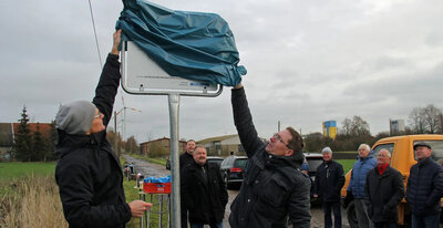 Enthüllung der Infotafel auf dem Zubringer-Feldweg durch Christian Kampe (links) und Matthias Finke. Ein identisches zweites Schild befindet sich am Hakenstedter Sportplatz, wo der erste Bauabschnitt endet.