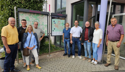 Einige Mandatsträger der gemeindlichen Gremien sowie Vorstandsmitglieder des Vereins für Tourismus und Bürgermeister Manfred Helfrich (links) bei der Übergabe der neuen Info-Anlage vor dem Rathaus Poppenhausen.