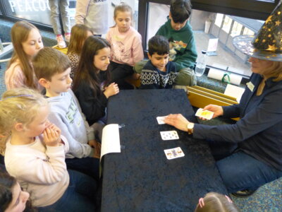 Gebannt verfolgen die kleinen Zauberlehrlinge, wie Sonja Klann die Karten legt. Können sie dem Trick herausfinden? Foto: Bürgerstiftung WML