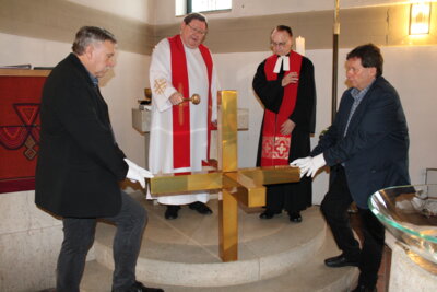 Die beiden Pfarrer Dr. Jürgen Henkel (links) und Werner Latteier weihen das neue Kirchturmkreuz der Martin-Luther-Kirche in Selb-Plößberg, das von den Kirchenvorstehern Udo Rödel und Joachim Reuer gehalten wird. Foto: Rainer Barthold/Pfarramt Erkersreuth. (Bild vergrößern)