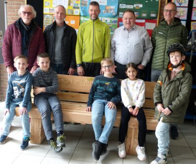 Kinder aus der 2c der Roncalli-Grundschule Weseke nahmen am Montag die Freundschaftsbank entgegen. Mit finanziert wurde diese vom Heimatverein Weseke, vertreten durch Manfred Benning (links), und dem Mühlenverein Weseke, vertreten durch Frank Dignath (2.v.l.) und Christian Rottstegge (Mitte). Mit dabei Schulleiter Donald Grüter und Ralf Fortmann (rechts) von der Tischler-Innung Borken. .Foto: Bürgerstiftung WML