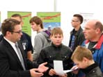 Am Stand der WDM GmbH lassen sich zwei Schüler und ihr Vater beraten.