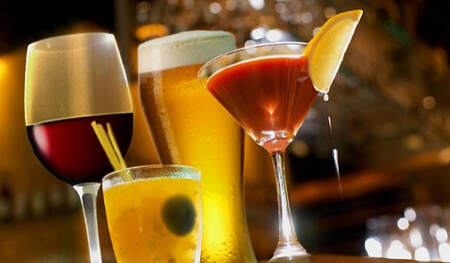verschiedene alkoholische Getränke stehen auf einer Bar; Rotwein, Bier und zwei Cocktails