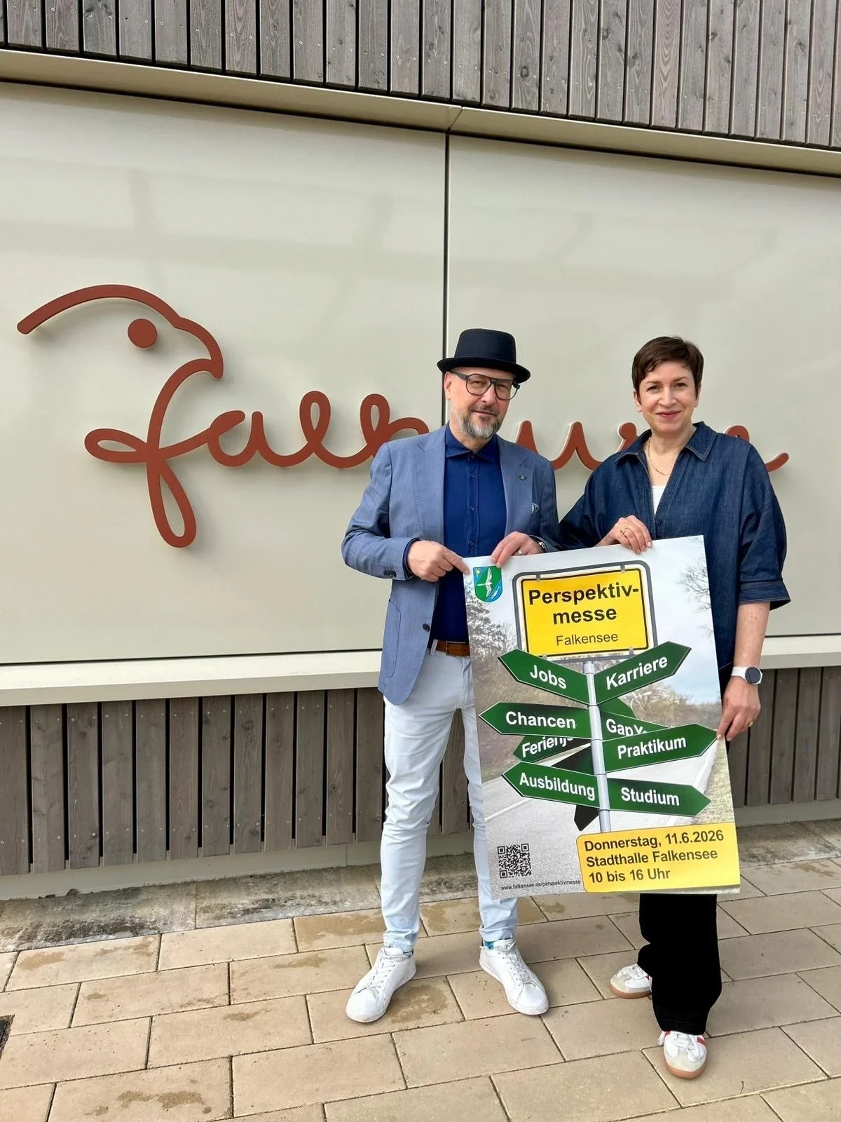 Bürgermeister hält das Plakat zur Perspektivmesse in die Kamera.