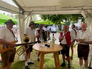 D´Wirtshausmusi im Weinzelt in Tracht gekleidet und mit Musikinstrumenten in der Hand