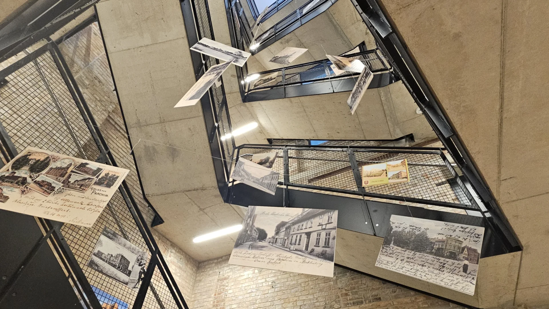 Treppenhaus Kulturmühle mit historischen Postkarten, die von der Decke hängen
