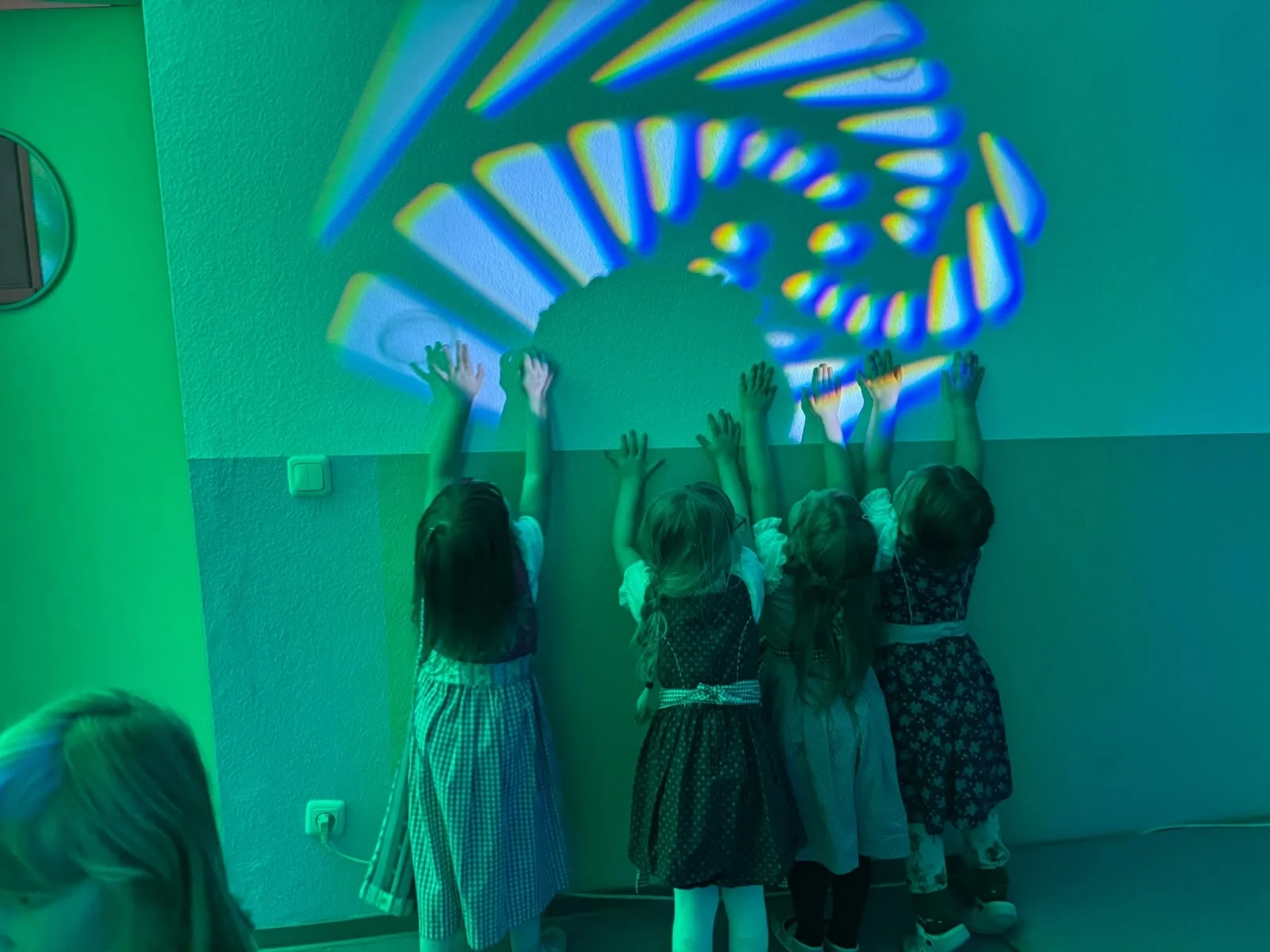 4 Kinder stehen mit Gesicht zur Wad und verfolgen ein Lichterspiel