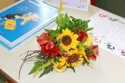 Fibel, Mathebuch, Stundenplan und ein Blumenstrau&szlig; warteten im Klassenzimmer auf die Kinder 