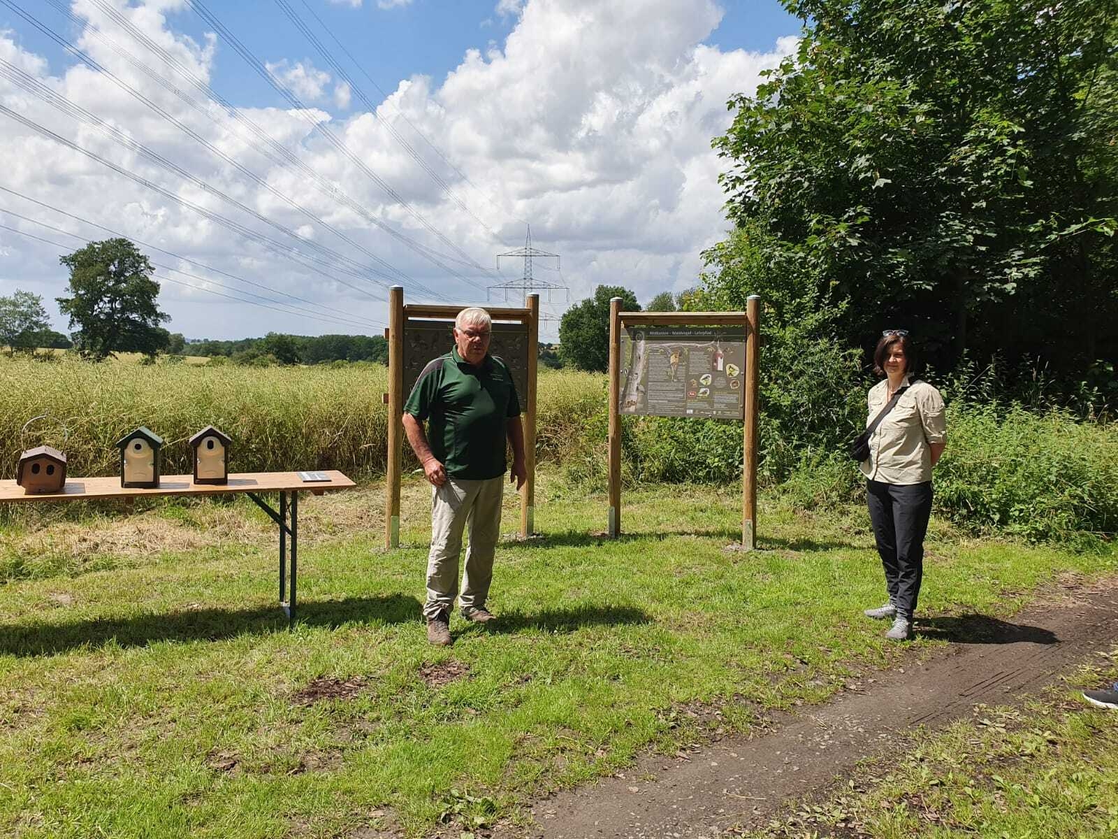Bild: Walter Kouril und Bianca Zydek (Geschäftsführerin des Naturparks Reinhardswald). Links im Bild die im Text erwähnten Nistkästen für Nischen- und Höhlenbrüter.