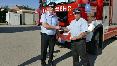 Gemeindebrandmeister Maik Wermuth (l.) und Ortsbrandmeister Christoph Hasenfu&szlig; (r.) mit dem symbolischen Fahrzeugschl&uuml;ssel 