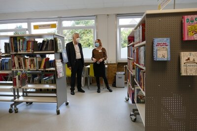 Frauke Backauf zeigt Dr. Rossmann die B&uuml;cherei. 