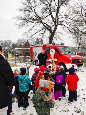 In Kemnitz half Ortswehrf&uuml;hrer Mario Bock dem Nikolaus beim Besuch im Garten der  Kita Rappelkiste. Foto: Privat  (Bild vergr&ouml;&szlig;ern)
