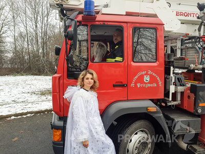 Das Team Nikolaus: Rommy Malorny als Engel, Christoph Falk als Nikolaus (beide vom Ordnungsamt) und Dirk Siemens von der Pritzwalker Feuerwehr. Wichtel Franziska Liebing steht hinter der Kamera.  (Bild vergr&ouml;&szlig;ern)