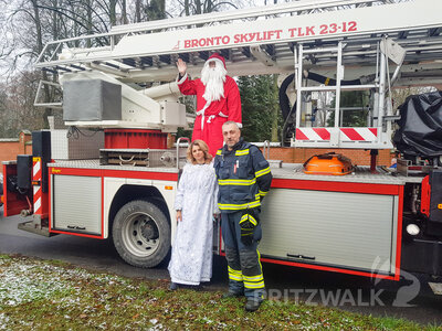 Das Team Nikolaus: Rommy Malorny als Engel, Christoph Falk als Nikolaus (beide vom Ordnungsamt) und Dirk Siemens von der Pritzwalker Feuerwehr. Wichtel Franziska Liebing steht hinter der Kamera.  (Bild vergr&ouml;&szlig;ern)