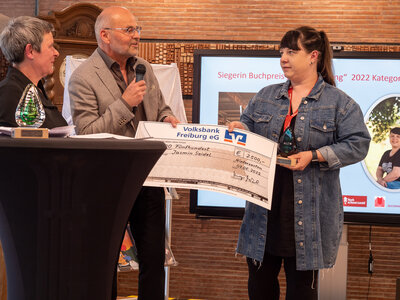 Jasmin Seidel (r.) erh&auml;lt den Buchpreis von Volker Haselbacher (HTG)  (Bild vergr&ouml;&szlig;ern)