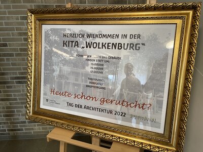 Vorschaubild: Die Kita Wolkenburg wird von der Architektenkammer Brandenburg als eines der gelungensten Bauwerke des Jahres gewürdigt. Das Schild verweist auf die Führungen durch das Gebäude im Rahmen des parallel zur Einweihung stattfindenden Tag der Architektur 2022.