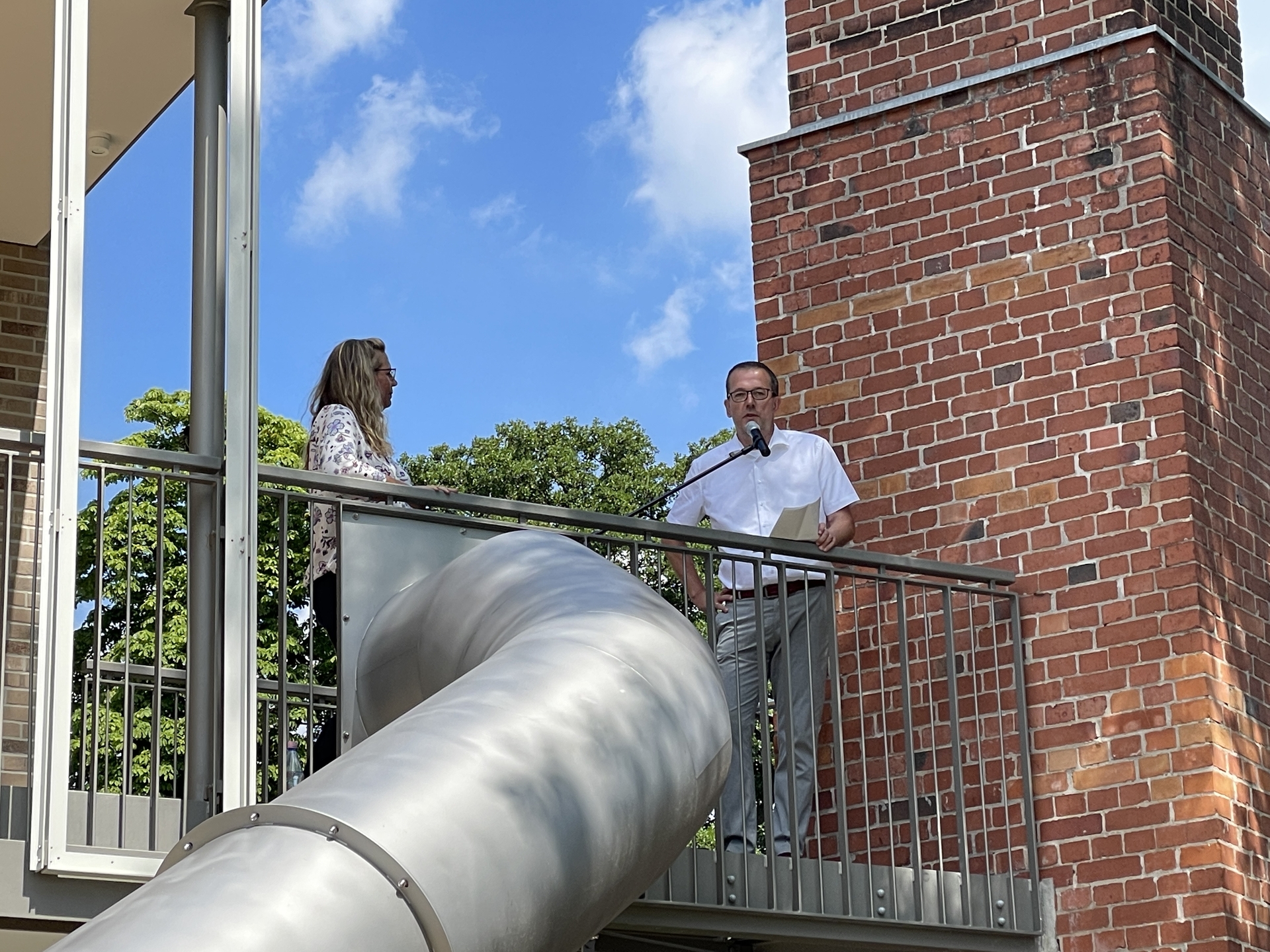 Bild: Herr Richter wendet sich an die Eltern, denen ebenfalls großer Dank für ihre Geduld während des großen Wasserschadens und der damit verbundenen Bauverzögerung gilt. Am Ende ist die Wolkenburg glücklicherweise doch keine ´Fluthütte´ oder ´Wasserburg´ geworden, wie er augenzwinkernd anmerkt. Den Kindern der Wolkenburg wünscht er eine tolle Zeit, viel Lernerfahrungen, Spaß und Freundschaften, die möglicherweise ein Leben lang halten.
