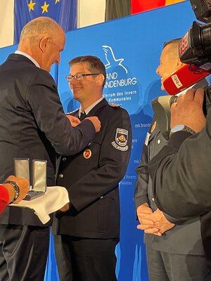 Ministerpr&auml;sident Dietmar Woidke &uuml;berreicht die Auszeichnung an Robert Abt, Feuerwehr Altd&ouml;bern. (Foto Landkreis)  (Bild vergr&ouml;&szlig;ern)