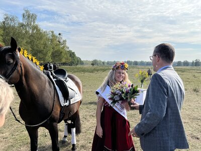 Vorschaubild: Bürgermeister Sven Richter überreicht der frisch gekrönten Heidekönigin einen Blumenstrauß.