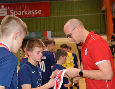 Vorschaubild: Matthias Reer, Vorsitzender Jugendausschuss, verteilt Silbermedaillen an die Jungs des SV BAbelsberg 03.