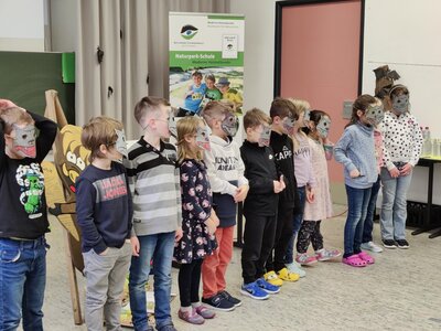 Mit selbst gebastelten Masken pr&auml;sentieren die Erstkl&auml;ssler voller Stolz und Leidenschaft ihr Wolfslied.  (Bild vergr&ouml;&szlig;ern)