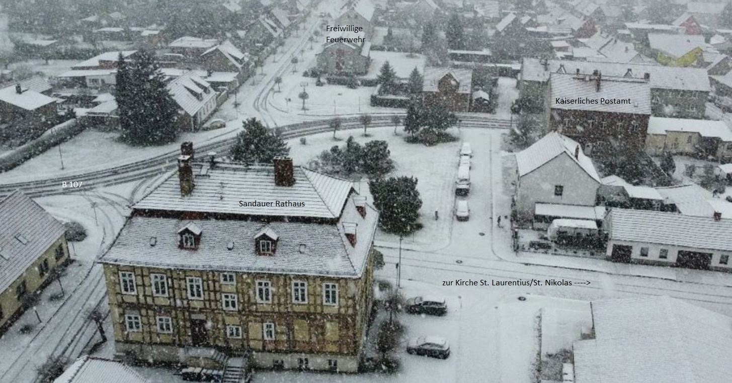 Bild: Das Sandauer Rathaus im Winter mit Blick über die Bundesstraße 107 Richtung Elbe auf die Freiwillige Feuerwehr und das Kaiserliche Postamt.